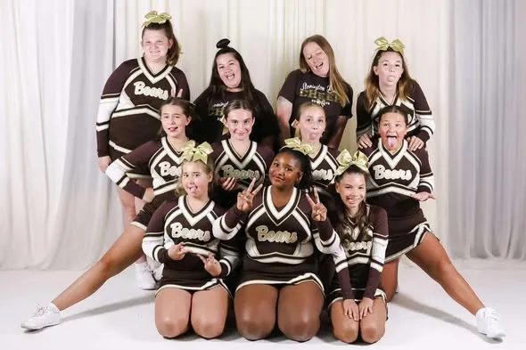 Stonington Bears cheer squad team photo in their brown and gold uniforms