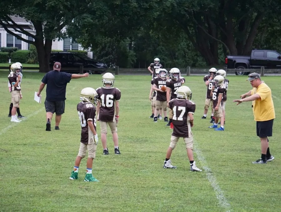 Bears coach guiding players through a drill